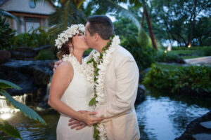 Couple with flower crowns and leis kissing